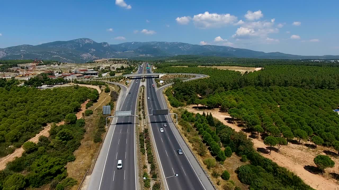 воздушный снимок над оживленным пересечением шоссе, которое проходит через пышные зеленые поля и луга