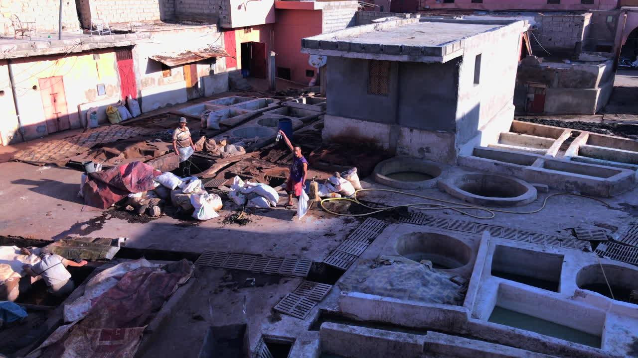 Wide shot of berber work at a tannery at Marrakech, Morocco