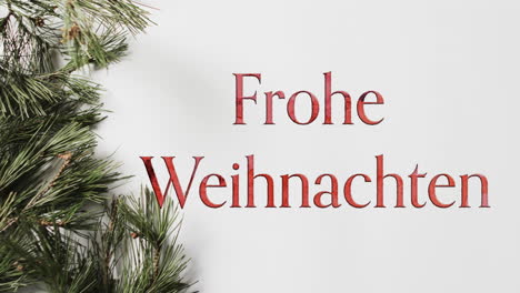frohe weihnachten text in red with christmas tree branch on white background