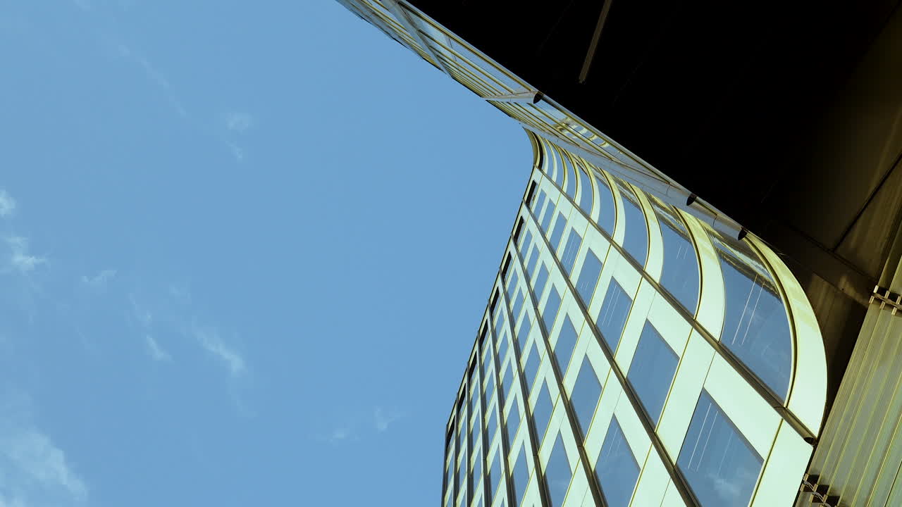 edificio de oficinas moderno con fachada de vidrio contra el cielo azul soleado