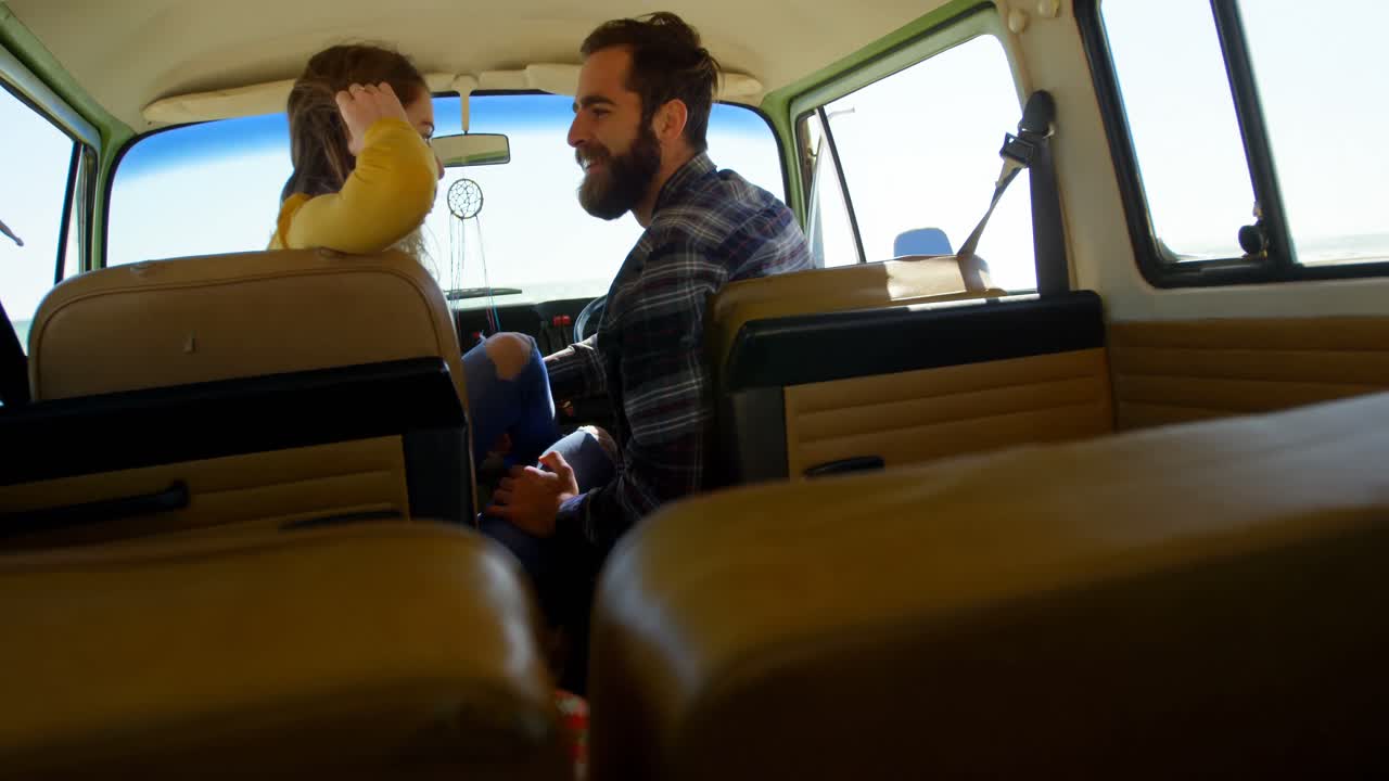 Pareja joven juntos en la furgoneta 4k