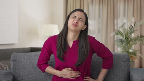 sick indian woman suffering from stomach pain