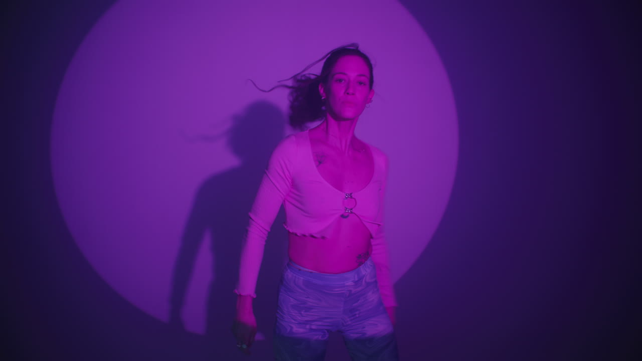 Woman Dancing Under a Purple Spotlight