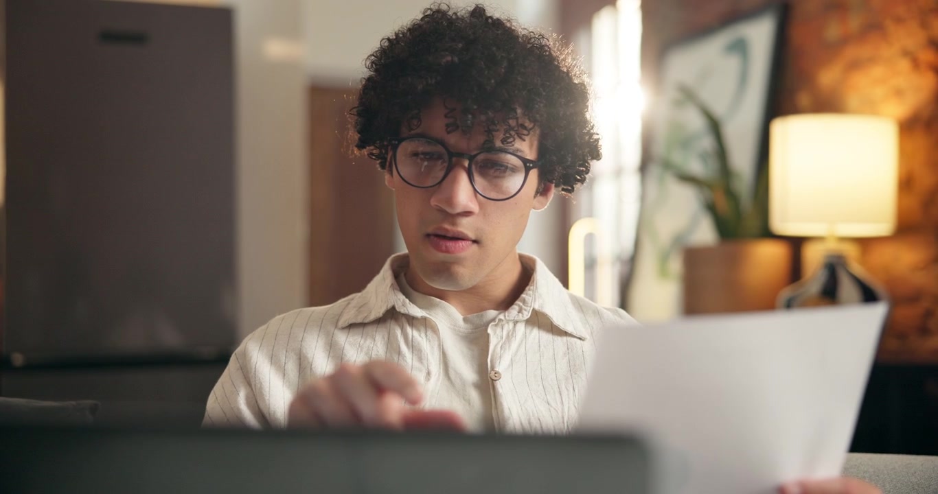 Young Man Working From Home Reviewing Documents
