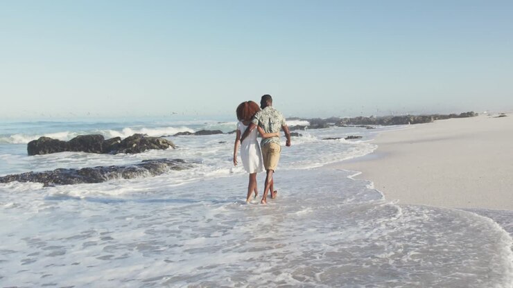 African American couple walking seaside
