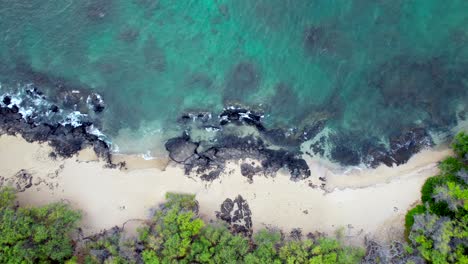 agua turquesa en una playa de arena y un arrecife rocoso en hawaii - vista aérea de pájaro hacia abajo