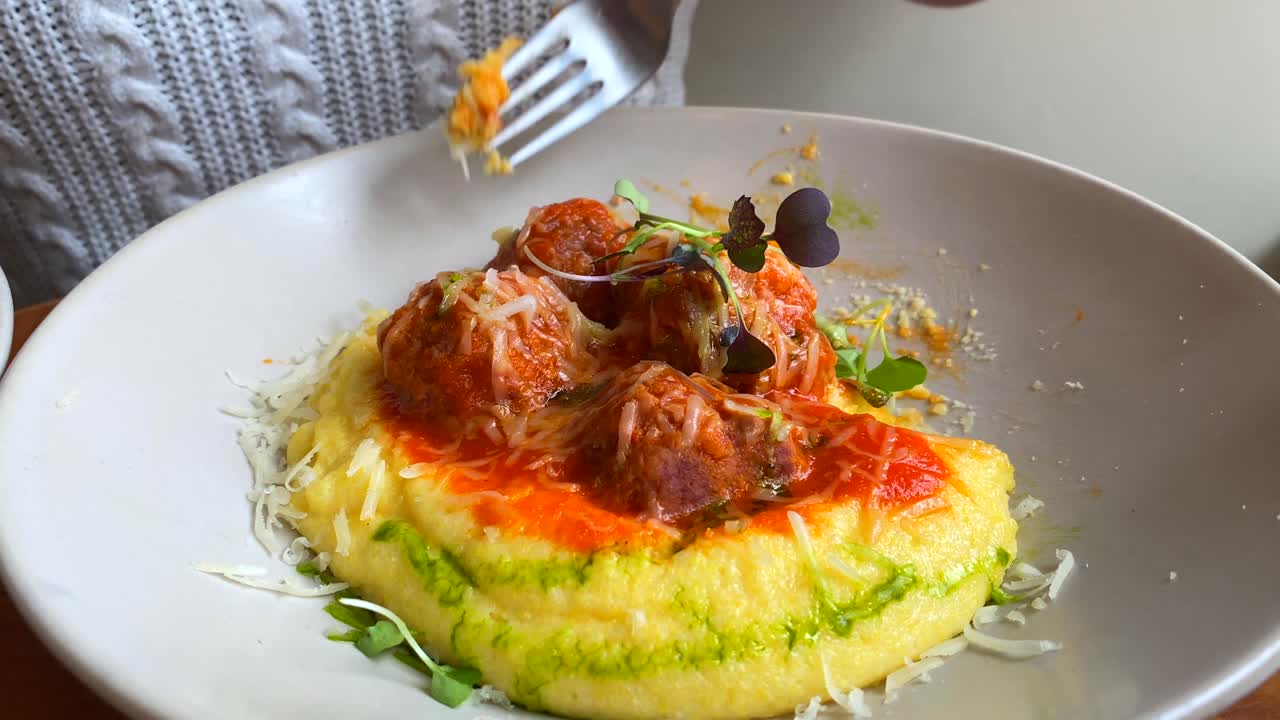 comiendo sabrosas albóndigas con polenta cremosa, microvegetales y queso, deliciosa comida en un plato, almuerzo, cena, tiro de 4k