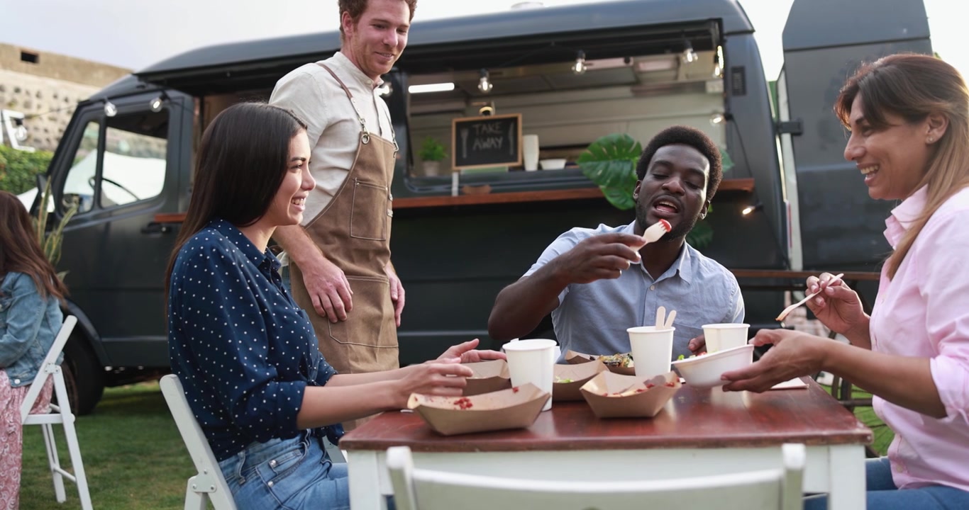 Happy Diverse Friends Eating at a Food Truck Outdoor Event