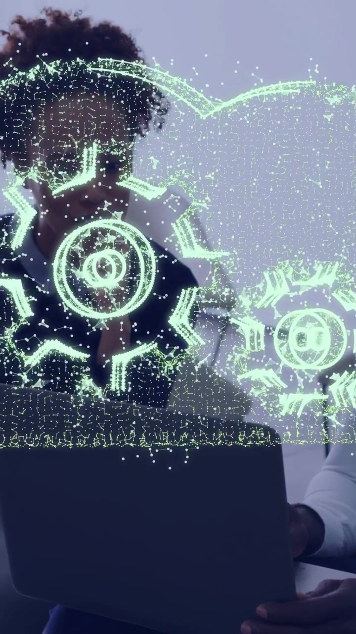 Vertical video: Woman viewing laptop man holding it streak spawning holo gears over reviewing tech