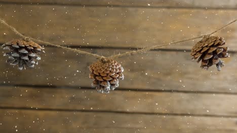 nieve cayendo con la decoración de cono de pino de navidad