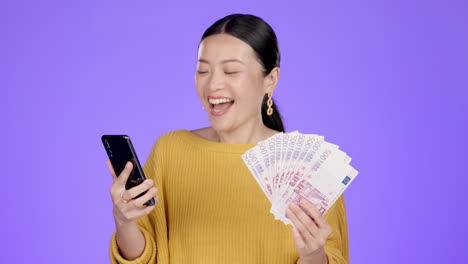 Teléfono,-Dinero-Y-Mujer-Asiática-Ganadora-En-El-Estudio.
