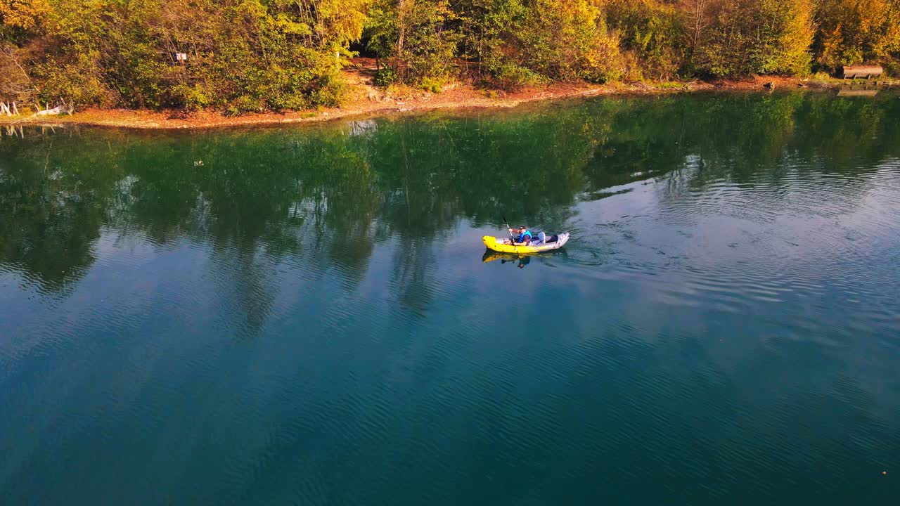 Splendide riprese aeree in 4K con drone di un canoista che pagaia attraverso un lago tranquillo