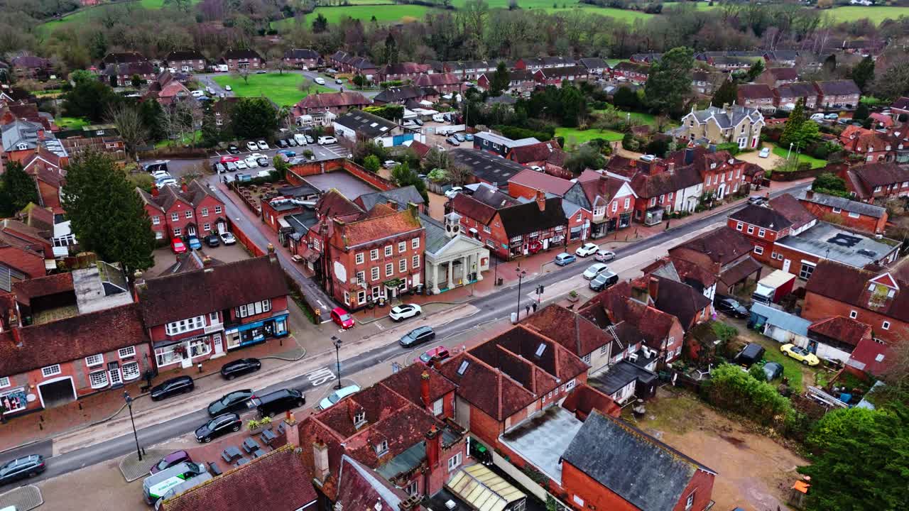 En panoramisk droneoptagelse fra luften over forstæderne til Southampton, med Botley landsbys boliger ved solnedgang på en overskyet vinterdag, med biler der passerer forbi på vejene nedenfor, forbi den lille bebyggelse i byen.