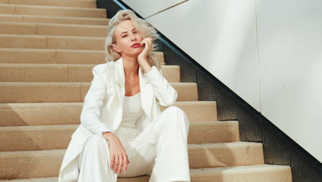 woman in white suit on stairs