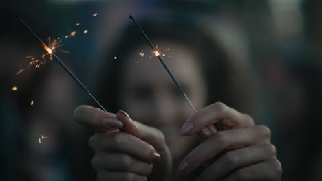 caucasian young woman  dancing on music festival with sparklers.