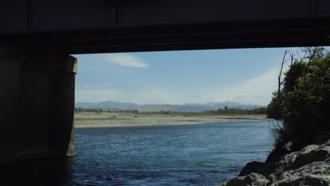 River-flowing-under-a-bridge-in-New-Zealand