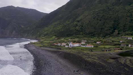 Pueblo-Rural-Costero,-Una-Iglesia-Con-Un-Exuberante-Paisaje-De-Acantilados-Verdes,-Fajã-De-Santo-Cristo,-Isla-De-São-Jorge,-Las-Azores,-Portugal