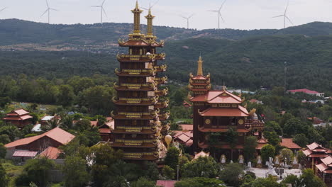 aerial of traditional south east asia buddhist temple zen tradition with windmill turbine in background, climate change human development concept