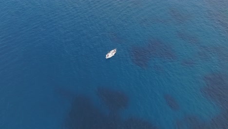 lone sailboat is crossing the crystal blue sea, pont d'en gil, menorca