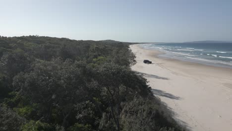 Paso-Elevado-De-La-Selva-Baja:-Camión-Estacionado-En-Una-Playa-De-Arena-Interminable,-Queensland,-Australia