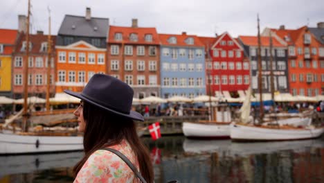 retrato de una mujer con sombrero mirando felizmente en el canal de nyhavn, copenhague