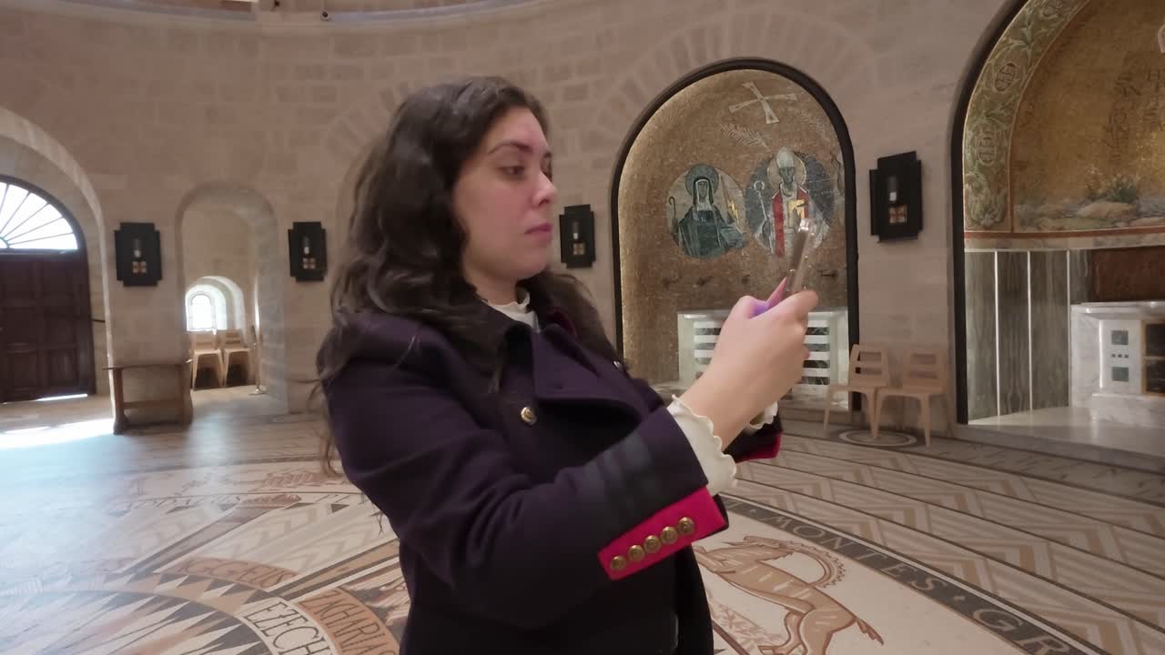 Young woman taking pictures inside Dormition Abbey in Jerusalem. Slow motion.
