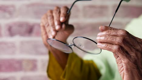 elderly person adjusting glasses