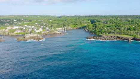 Vista-Aérea-De-La-Hermosa-Bahía-Azul-En-Boca-De-Yuma-Con-Paisaje-De-Bosque-Verde-Durante-La-Luz-Del-Sol,-República-Dominicana