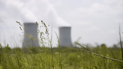 nuclear power plant out of focus in background in a field