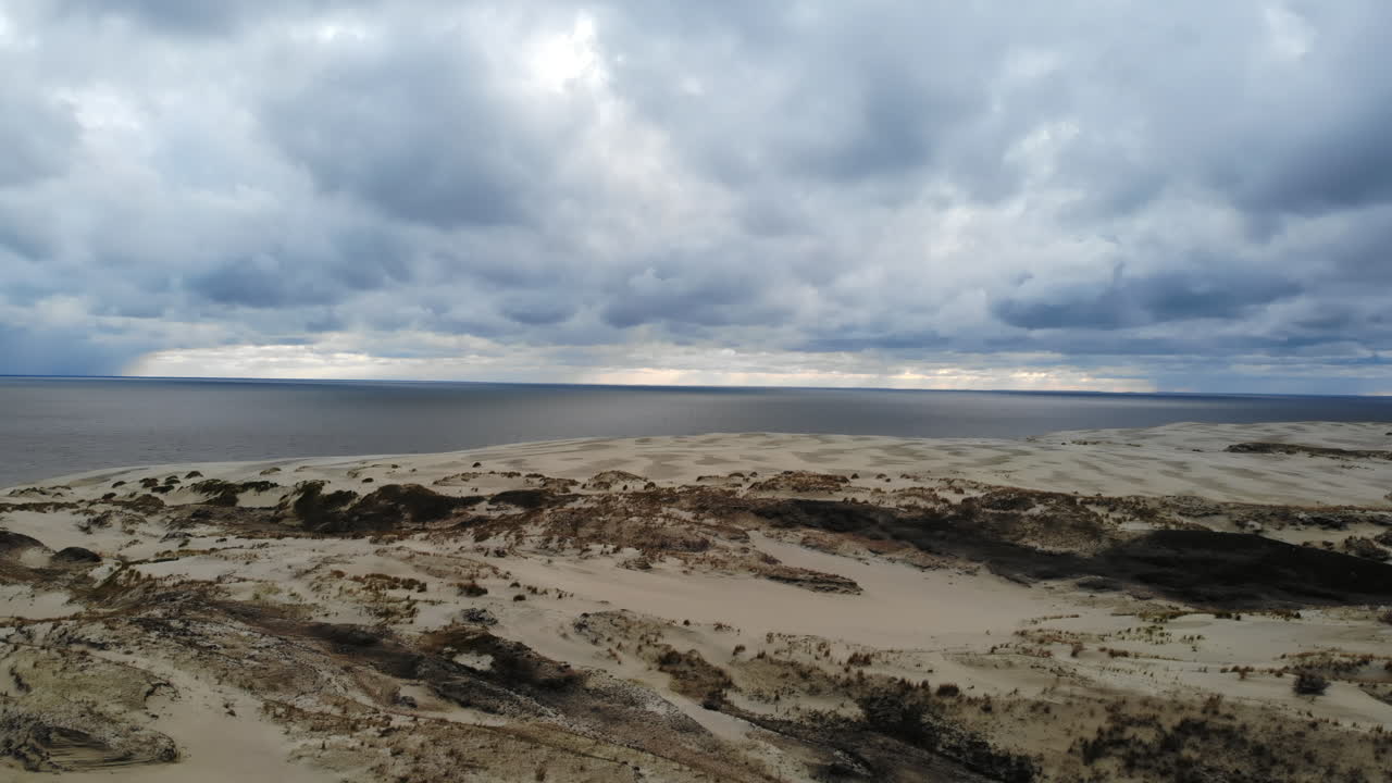 Sand Dunes by the Sea under Cloudy Sky