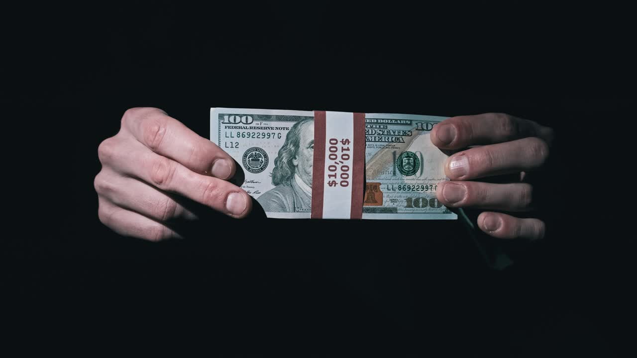 검은 바탕에 남성의 손에 인 1만 달러 어리.