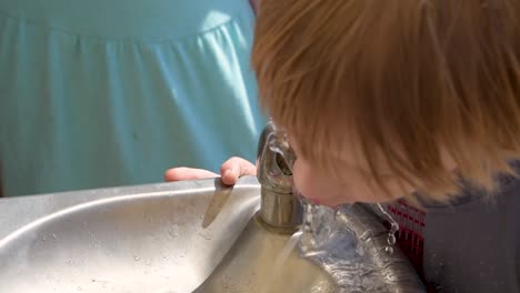 Kleiner-Junge-Holt-Wasser-Aus-Dem-Trinkbrunnen