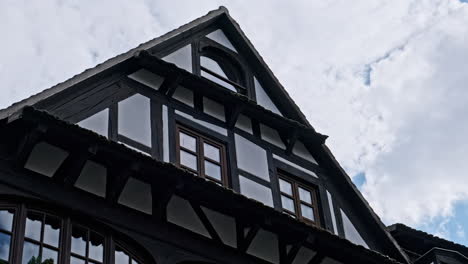 upper part of a traditional half-timbered house against a cloudy sky
