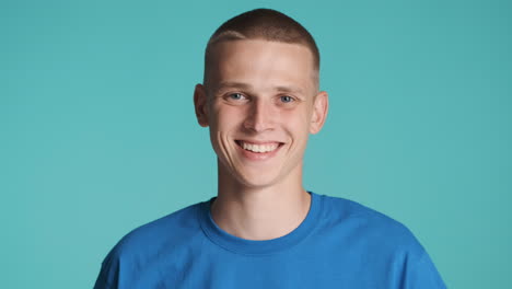 joven feliz con ojos azules posando