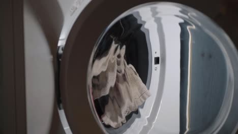 hand loading washing machine with clothes and closing door