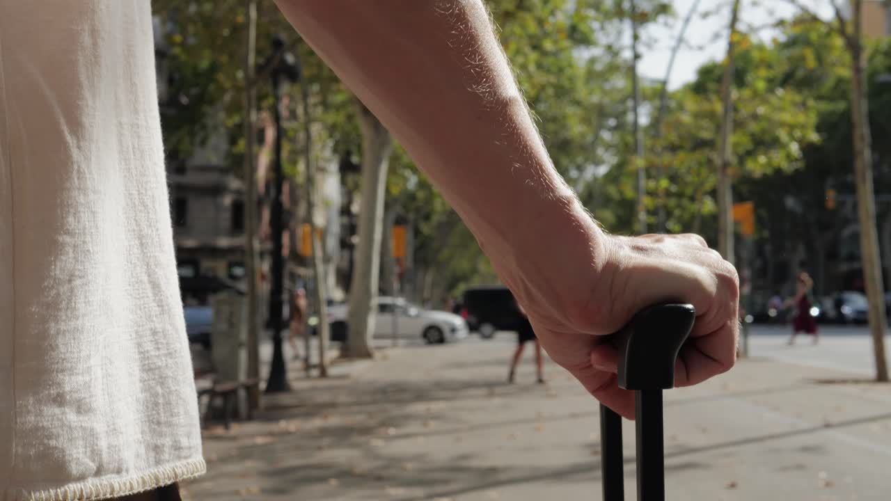 Person pulling a suitcase on a city street