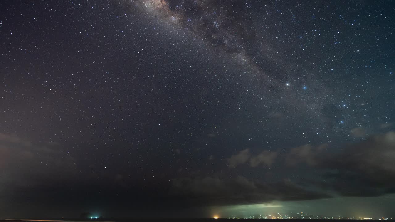 Night Sky Over the Ocean with Clouds and City Lights