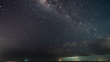 Night Sky Over the Ocean with Clouds and City Lights