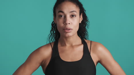 una mujer afroamericana segura de sí misma sobre un fondo azul.