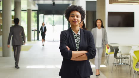 portrait of businesswoman ceo chairman standing in lobby of busy modern office building