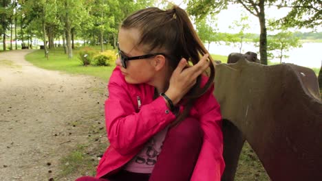 girl with red jacket sitting in the park