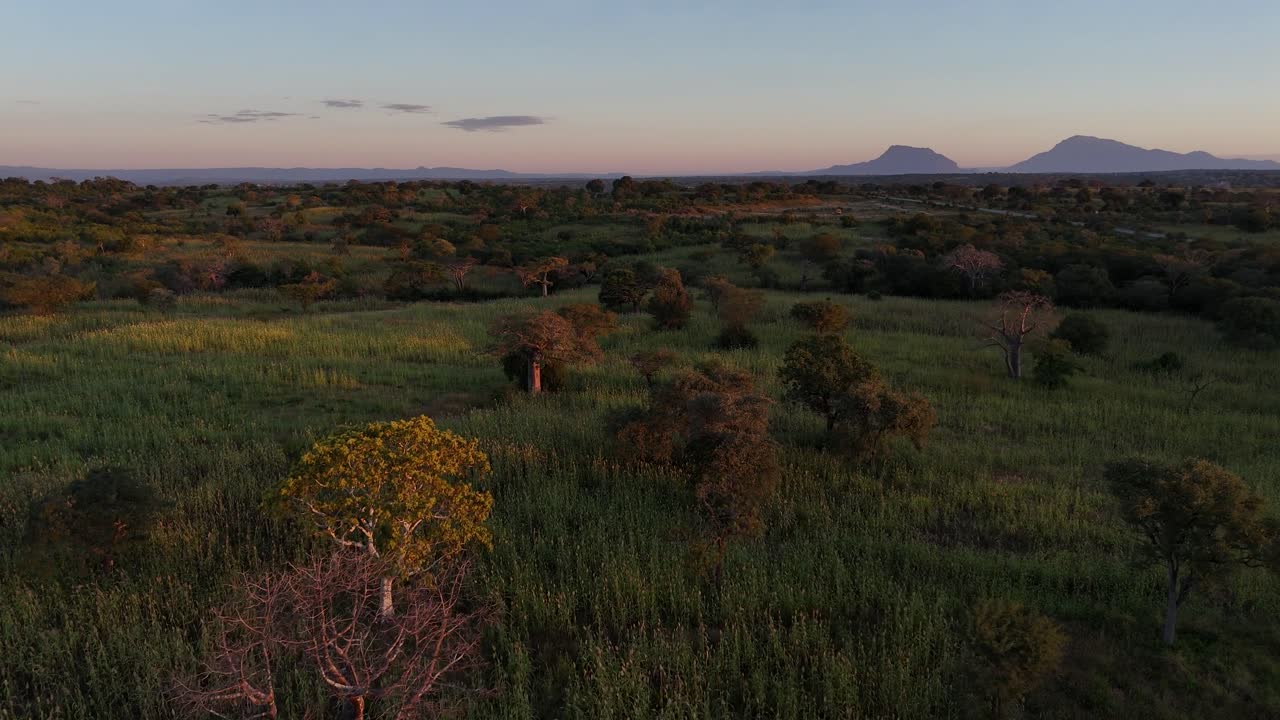 drone Aerial view of sunset over rural Lubango, Angola, revealing warm tones across hills, grassland, and the quiet open plains of southern Africa
