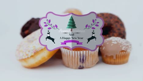 Animation-of-christmas-greetings-on-tag-over-cupcakes-on-white-background