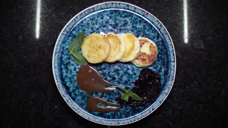 pasteles de queso con pasta de chocolate y mermelada. comida giratoria. comida saludable dietética. cocina de primer plano deliciosa. presentación de un plato de restaurante en un hermoso plato elegante. mostrando una obra maestra culinaria