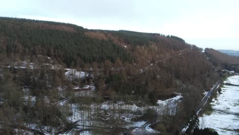 Snowy-Welsh-woodland-Moel-Famau-winter-national-park-landscape-aerial-tilt-down-view
