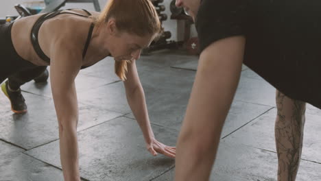 an athletic woman and a strong man do abdominal exercises