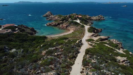 volando a lo largo de una idílica bahía natural de la playa de la costa en la isla de vacaciones turísticas cerdeña en italia con sol, azul turquesa claro y aguas tranquilas cerca de capo testa