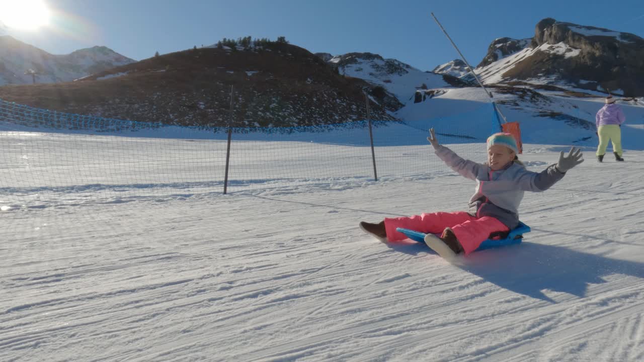 женщина катается на санях в горах.