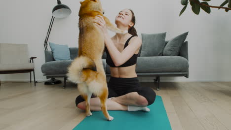 a girl takes a break from her yoga session to play with her cute dog 2