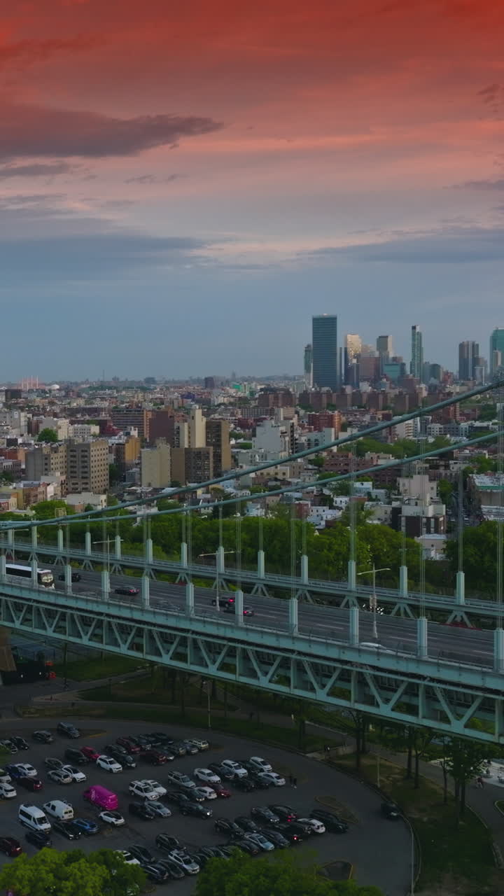 Impressive red sky over the huge metropolis. Busy traffic on the Triborough bridge in New York. Evening falling on the city. Vertical video